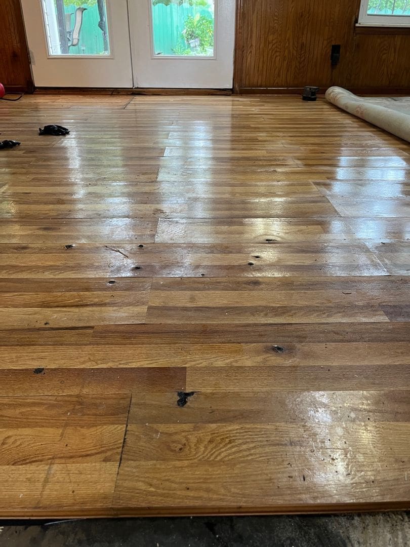 Water-damaged hardwood floor before restoration