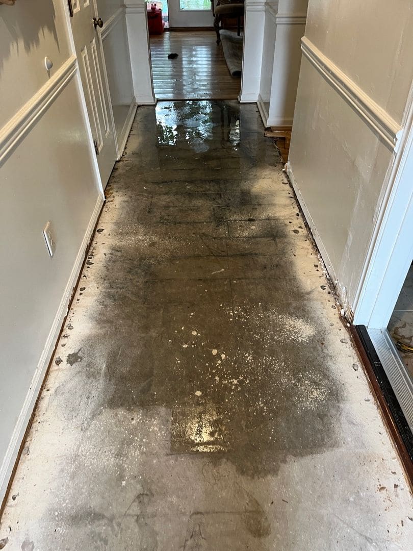 Hallway with standing water across the floor before cleanup
